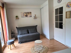 A modern living room with a grey sofa, a round coffee table, and a small side table.