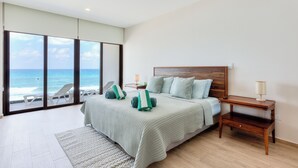 A bedroom with a large sliding glass door leading to a balcony with a view of the ocean. - Spacious 3-Bedroom Apartment in Fabulous Isla Mujeres (Isla Mujeres)