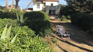 A house with a red roof, surrounded by dense greenery and trees. - Charming villa with garden and sea view (Fréjus)