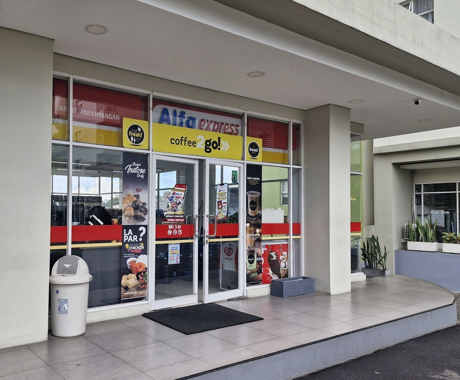 A storefront with a sign for 'Alfa Express' and a 'coffee 2 go!' sign.