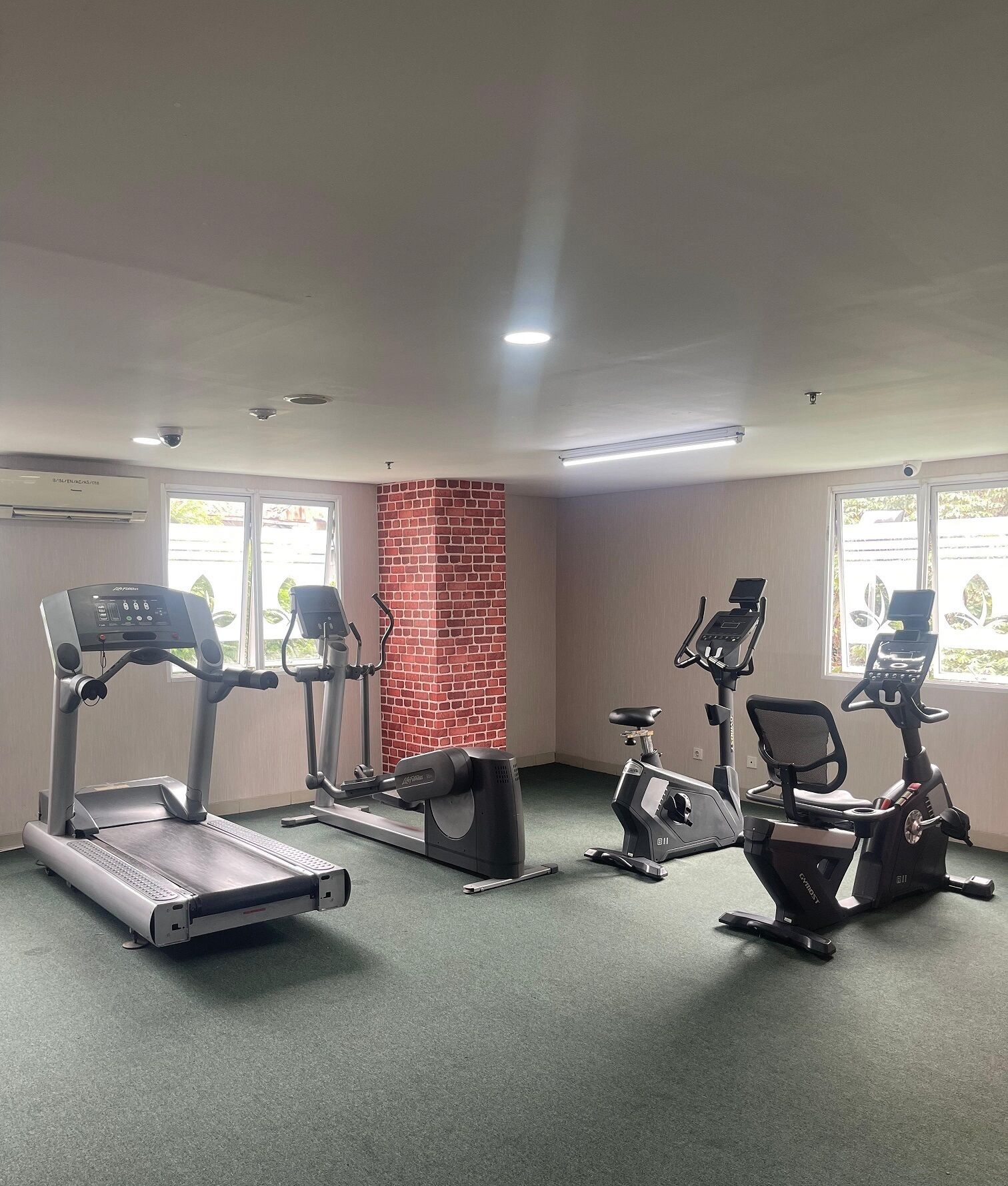 Une salle de sport équipée de tapis de course, d’appareils elliptiques et de vélos d’appartement.