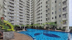 Een meerlaags appartementencomplex met een zwembad.