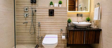 Un baño moderno con ducha, inodoro, lavabo y espejo.