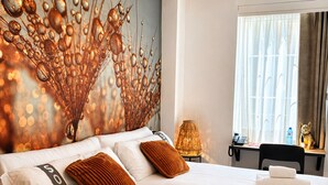 A hotel room with two beds, a decorative wall, a lamp, a desk, and a window with curtains.