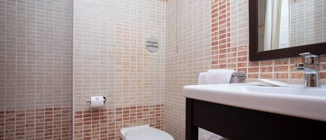 A bathroom with a toilet, sink, and towel rack.