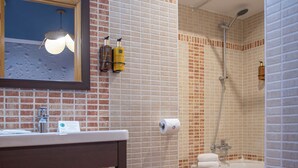 A bathroom with a sink, mirror, and a shower area.