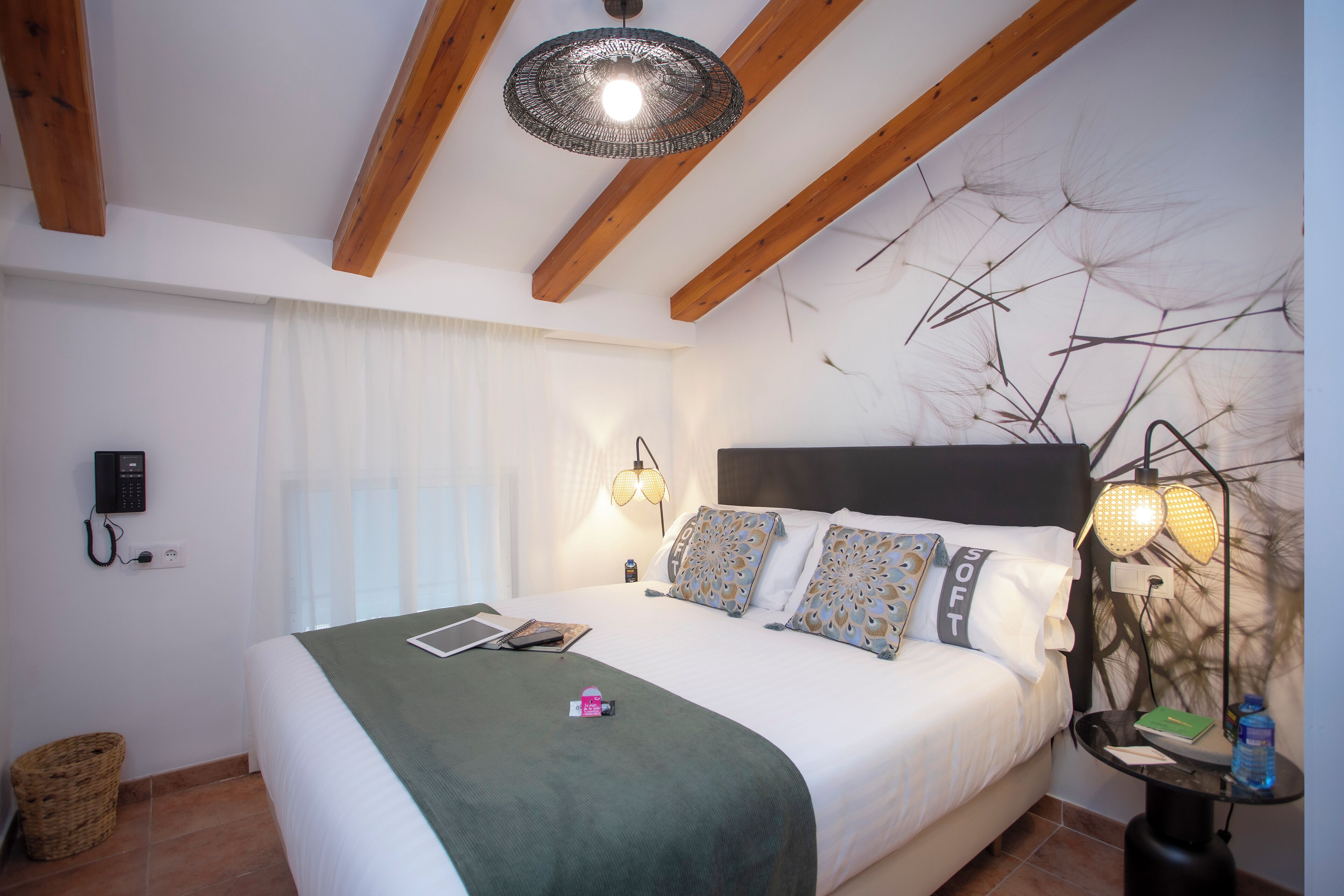 Une chambre à coucher avec un lit, des lampes de chevet, une table de chevet et un téléphone fixé au mur.