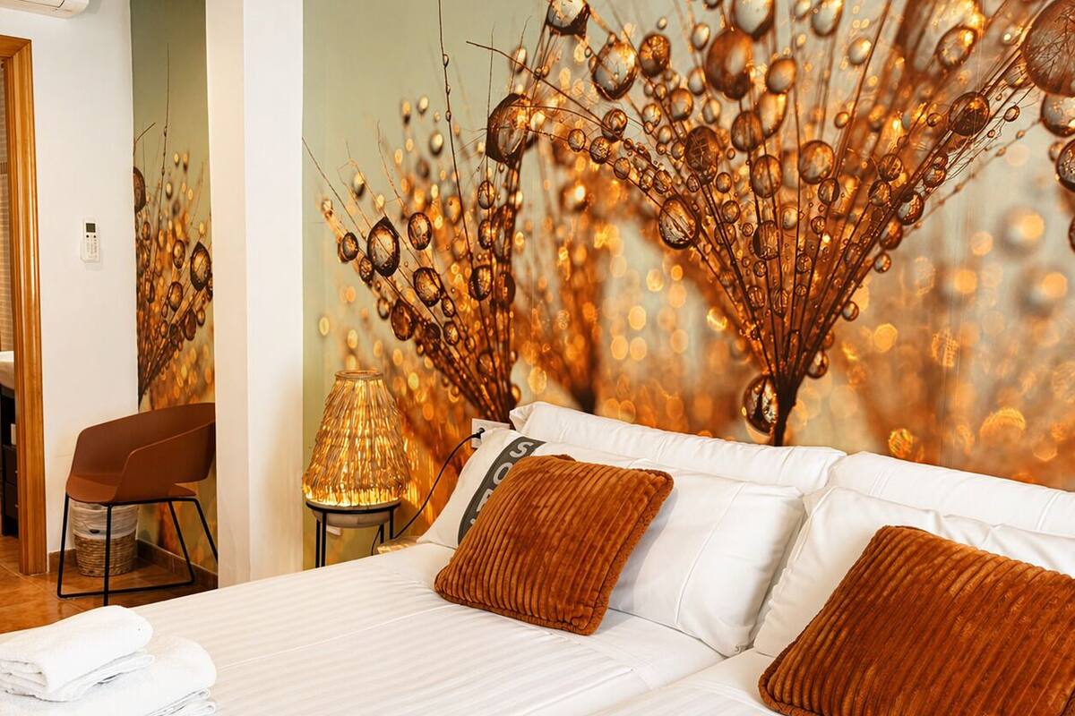 Une chambre d’hôtel avec un grand lit, une chaise, une lampe et un mur décoratif.
