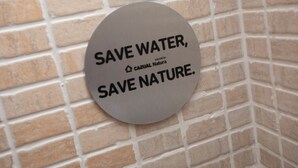 A circular sign with the text "SAVE WATER, SAVE NATURE."