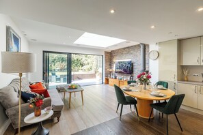 Un salon moderne comprenant un canapé, une table basse et un coin repas avec une table et des chaises.