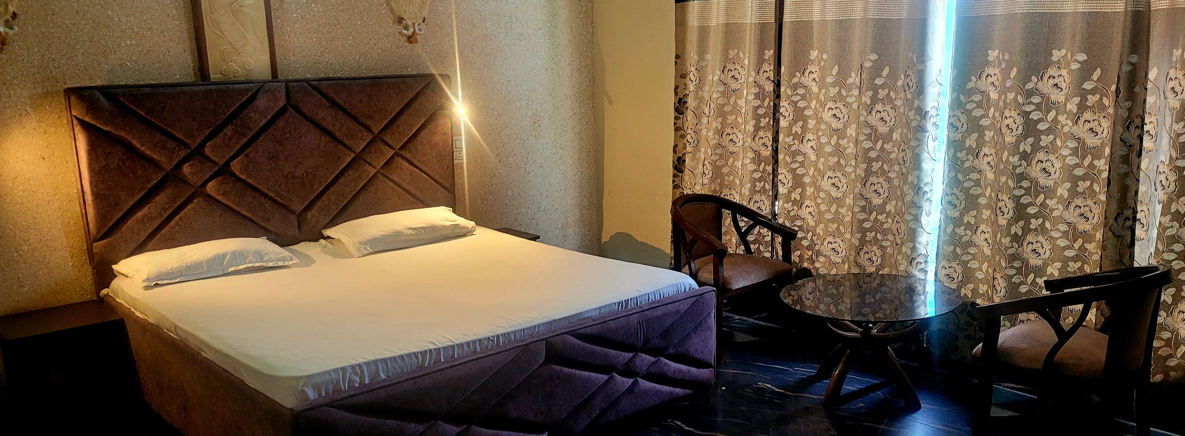Ein Hotelzimmer mit einem Bett, einem Sessel und einem kleinen Tisch.