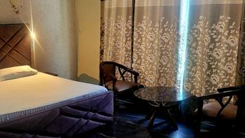 Ein Hotelzimmer mit einem Bett, einem Sessel und einem kleinen Tisch.
