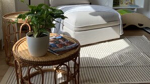 Une chambre confortable avec un lit, des tables de chevet, une plante en pot, une lampe et une bibliothèque.