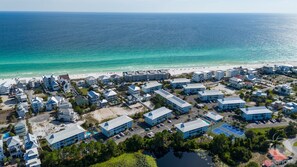 An aerial view of a coastal resort with multiple buildings, a beach, and a marina.
