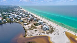 Vista aérea de una zona residencial costera con casas, una playa y un puerto deportivo.