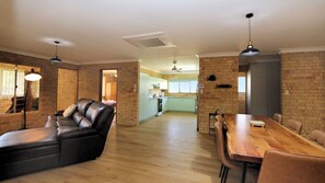 Relax in this stylish living area with a leather sofa, dining table, and modern kitchen.