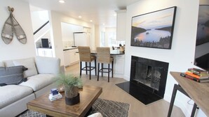 A modern living room with a sofa, a coffee table with a plant, and a fireplace. - Mountain Views Condo | Community Pool & Hot Tub (Zephyr Cove)