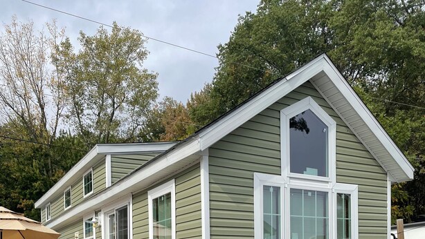 A two-story house with a front porch, a small deck, and a garage. - Great Getaway in adorable Cherokee Landing at Indian Lake with AC, WiFi (Lakeview)