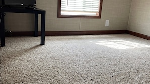 A room with a large window, carpeted floor, and a television on a stand. - Great Getaway in adorable Cherokee Landing at Indian Lake with AC, WiFi (Lakeview)