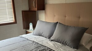 A bedroom with a large bed, a nightstand, and a wardrobe. - Great Getaway in adorable Cherokee Landing at Indian Lake with AC, WiFi (Lakeview)
