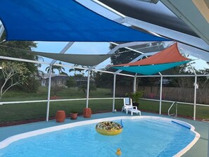 Une piscine couverte avec un flotteur circulaire et un petit jouet gonflable.