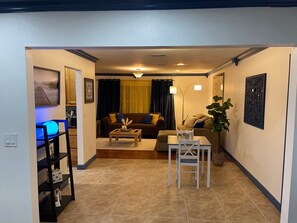 Ein Wohnzimmer mit einer Couch, einem Couchtisch und einem Essbereich mit einem Stuhl und Tisch.
