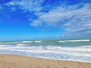 Une plage avec des vagues et un ciel dégagé.