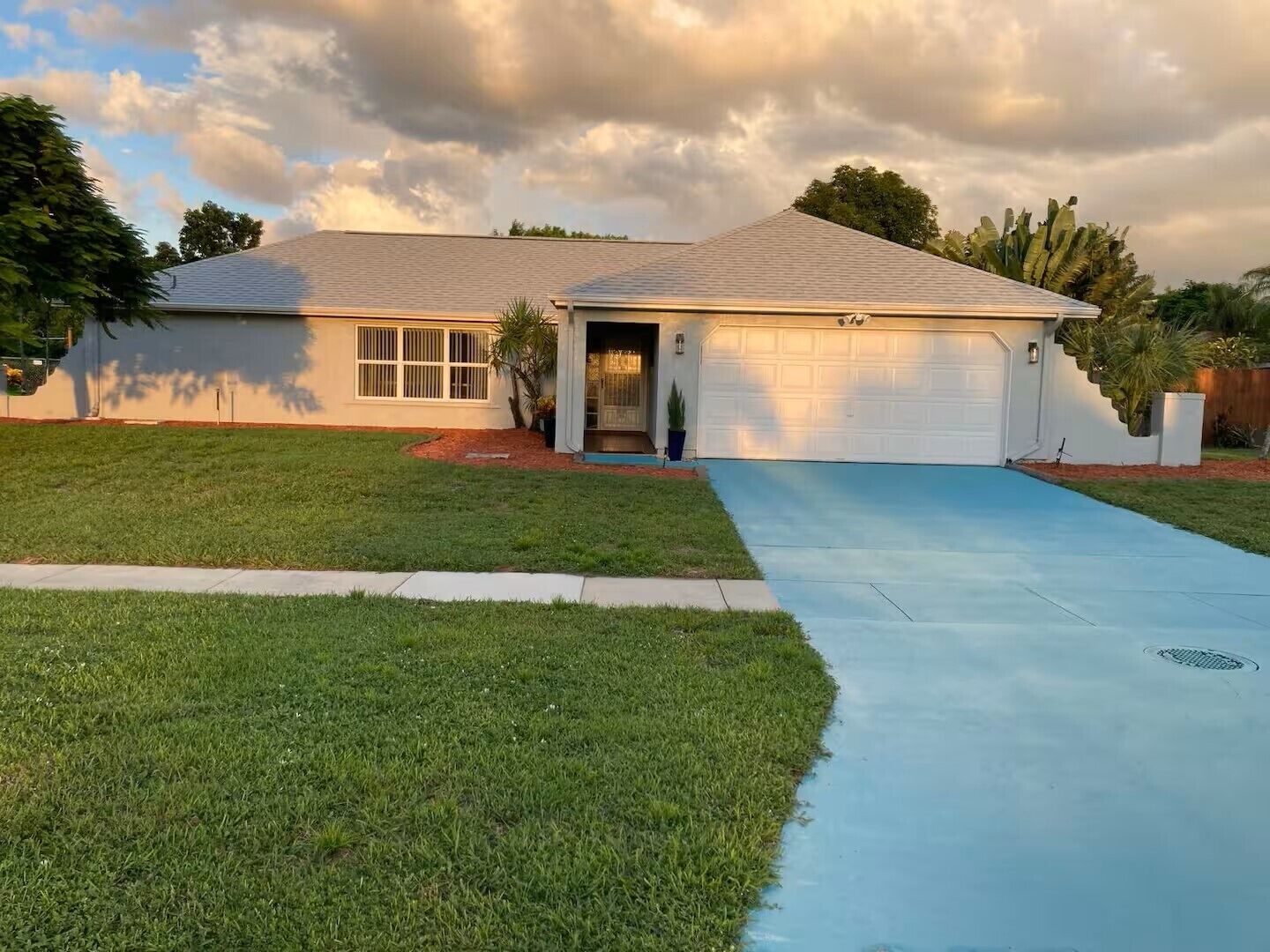 A single-story house with a garage, a front yard, and a driveway.
