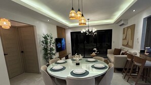 Een moderne eetruimte met een ronde tafel voor vier personen, omringd door stoelen.