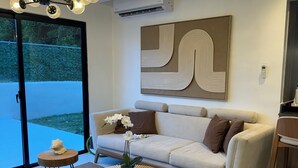 Een moderne woonkamer met een bank, bijzettafeltje en decoratieve objecten.