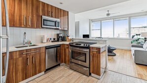 Eine moderne Küche mit Holzausstattung, Edelstahlgeräten und einem großen Fenster mit Blick auf die Stadt.