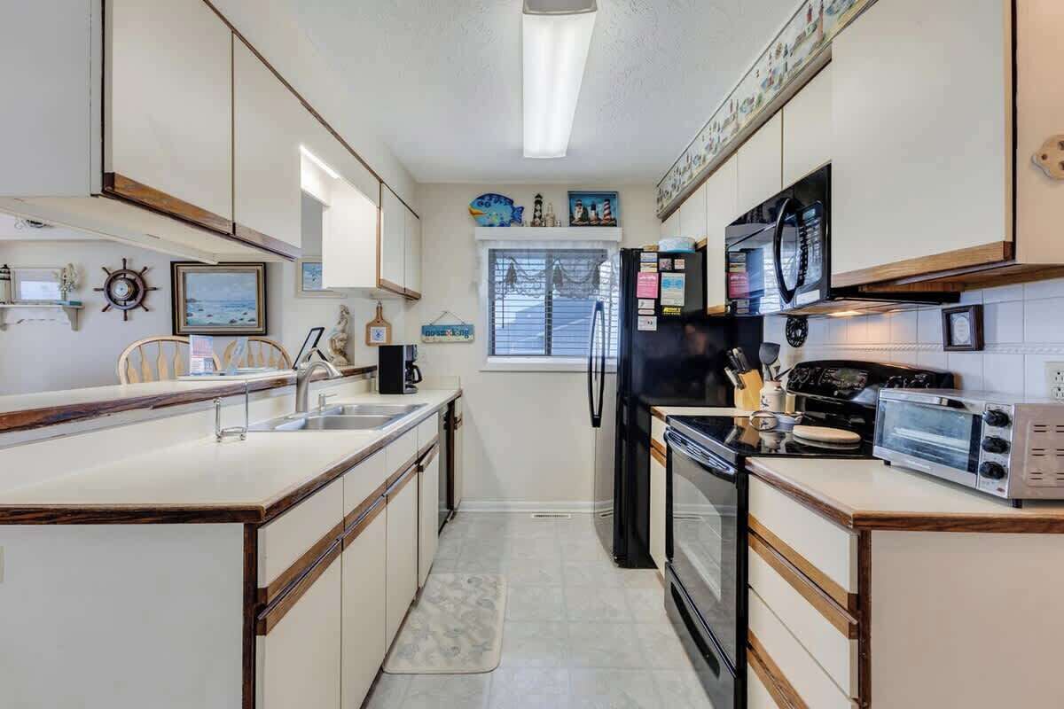 A compact kitchen with a central island, built-in appliances, and decorative elements on the walls.