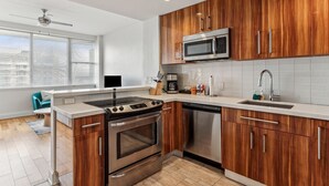 Une cuisine moderne avec des meubles en bois, des appareils électroménagers en acier inoxydable et une grande fenêtre.