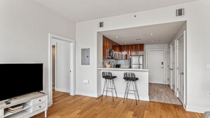 Un appartement moderne comprenant un salon, une cuisine et un coin repas.