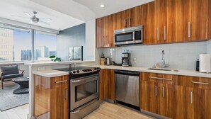 Una cocina moderna con armarios de madera, electrodomésticos de acero inoxidable y vistas a la ciudad.