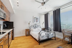 Une chambre à coucher de taille modeste, comprenant un lit, une table de chevet et une fenêtre avec des rideaux.