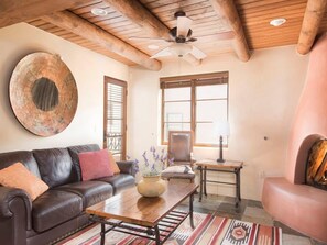 A cozy living room with a leather sofa, a coffee table, and a fireplace.
