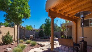 An outdoor patio area with a pergola, seating, and a wood-burning stove. - Casa Loma in Santa Fe (Santa Fe)