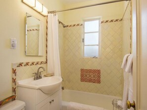 Un bagno con lavandino, specchio e zona doccia.