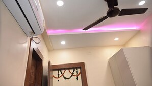 Una habitación con ventilador de techo, luces empotradas y aire acondicionado de pared.