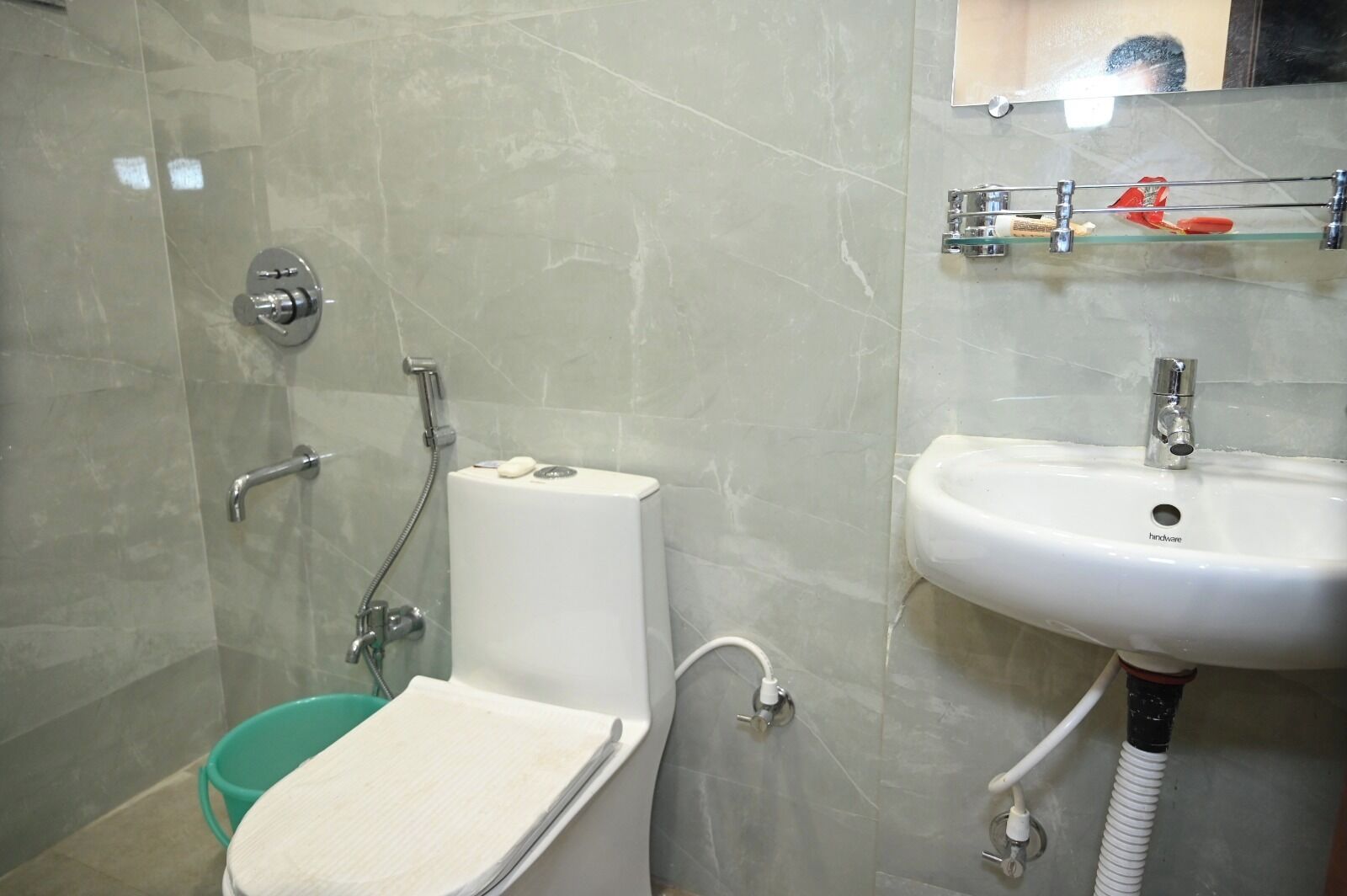 A bathroom with a toilet, shower, and sink.