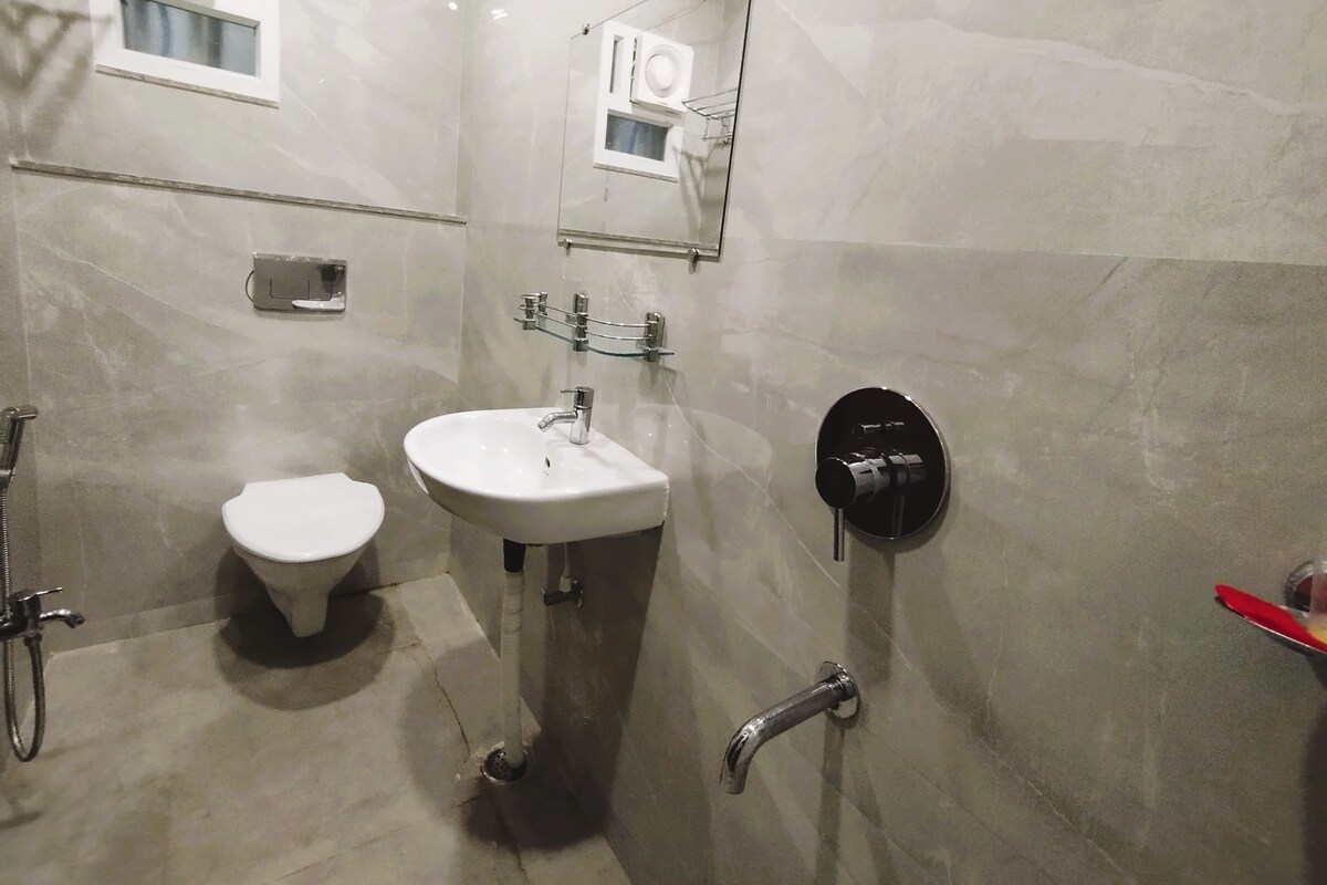 A bathroom with a toilet, sink, and shower.
