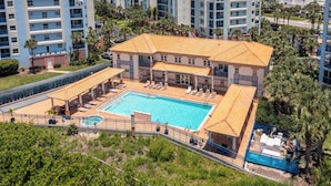 Un hotel con piscina, diversi balconi e vista sull'oceano.