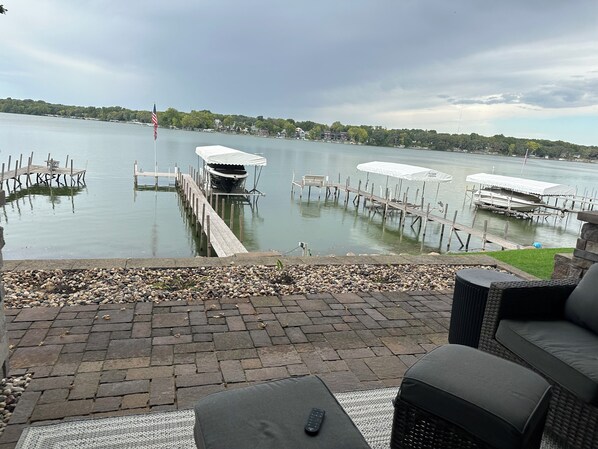 Eine Terrassenausstattung am Seeufer mit Steg, Gartenmöbeln und Blick auf das Wasser.