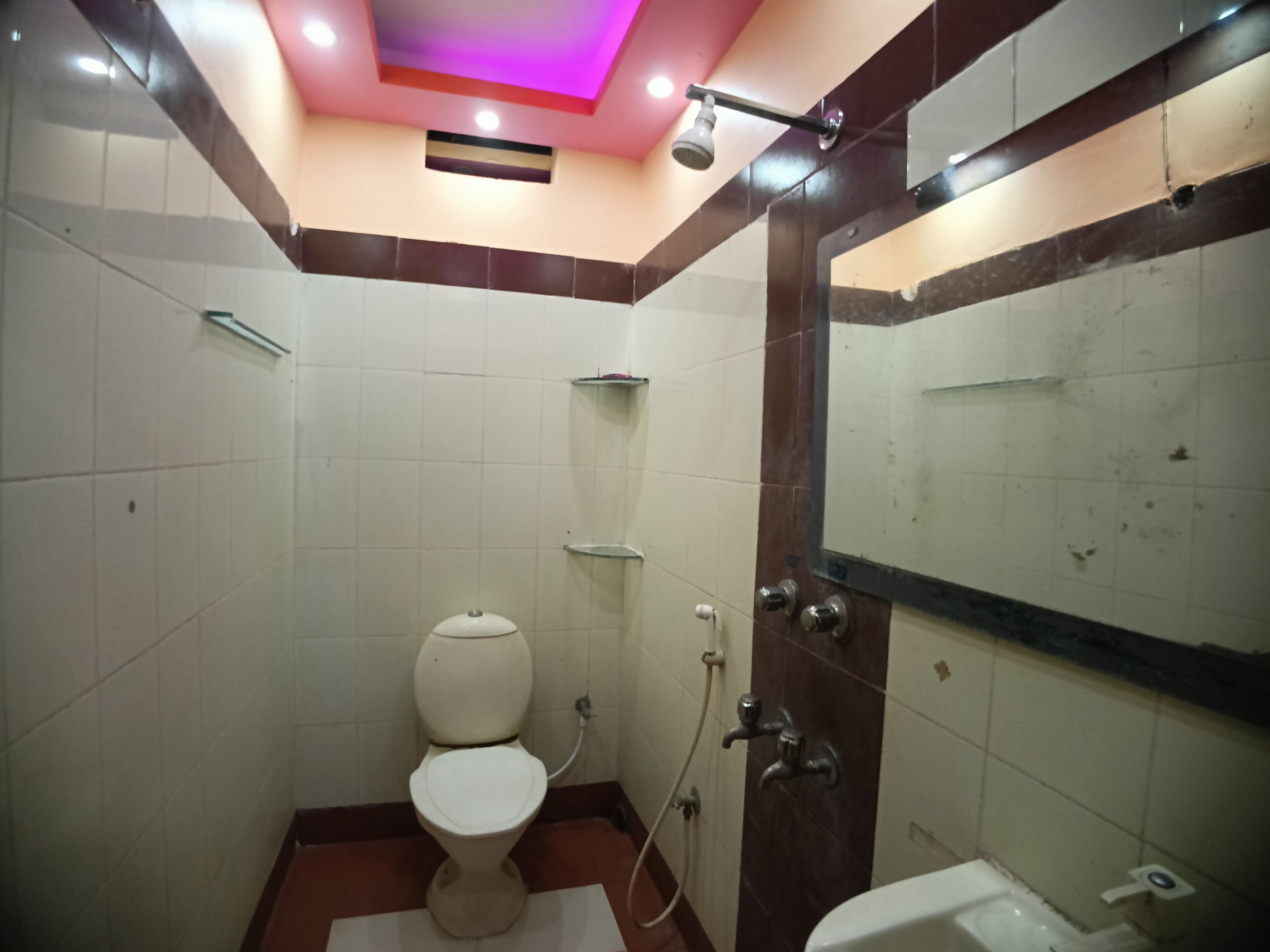 A small bathroom with a toilet, a shower, and a sink.