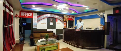 A reception area with a reception desk, a sofa, a coffee table, and a fish tank.
