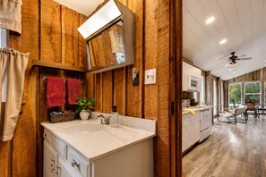 Een houten interieur met een badkamer, keuken en eetgedeelte.
