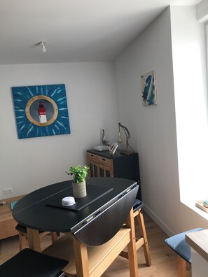 Relax in this serene space with a round table, potted plant, and comfortable bench.