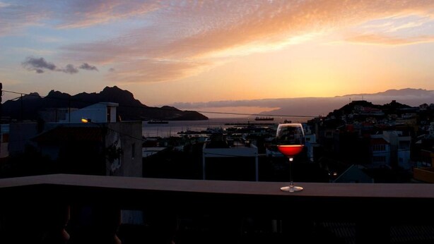 A sunset view from a balcony with a glass of red wine. - Vila Mira Mar (São Vicente)
