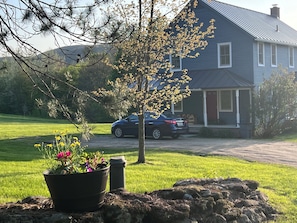 A house with a driveway, a parked car, and a lawn.